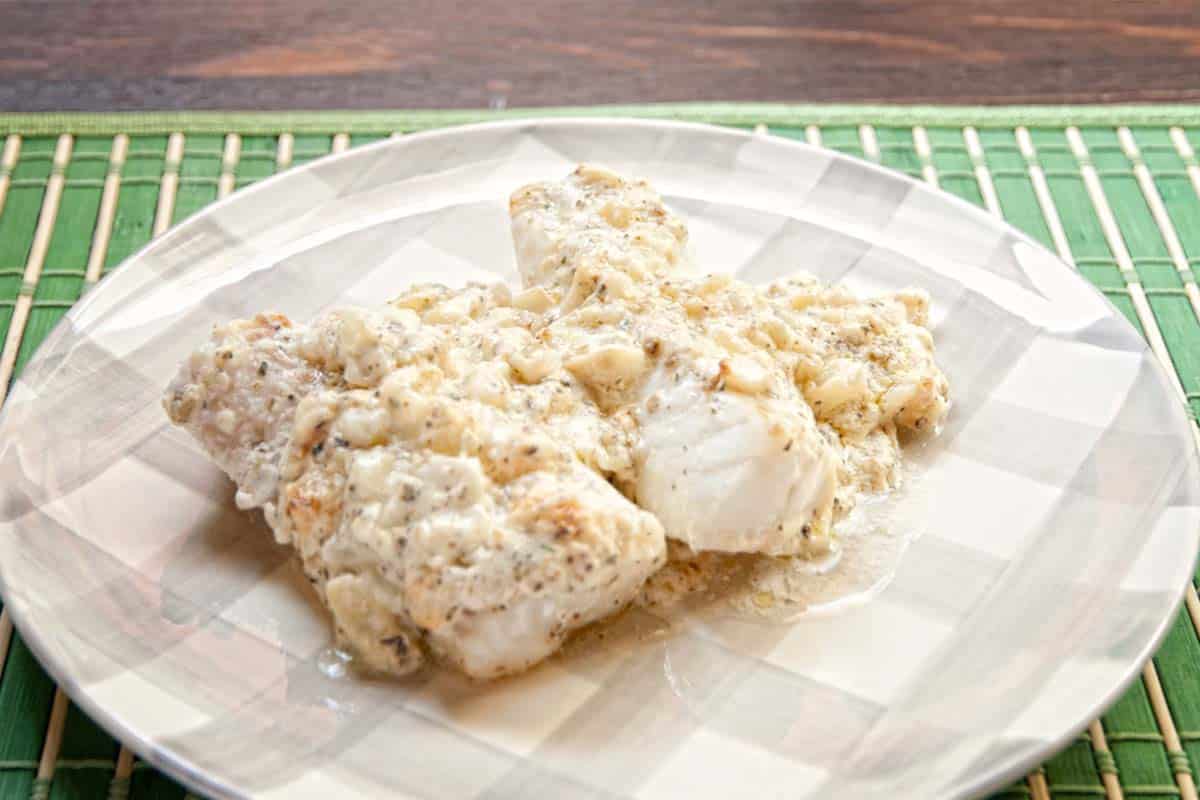 serving of baked cod with creamy dill sauce on a plate